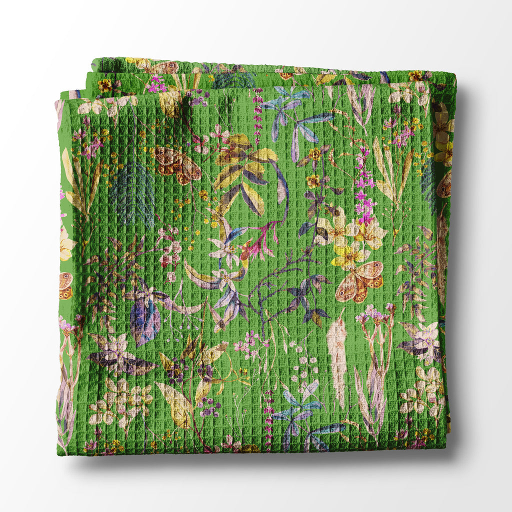Folded green kitchen towel with floral pattern on a white background