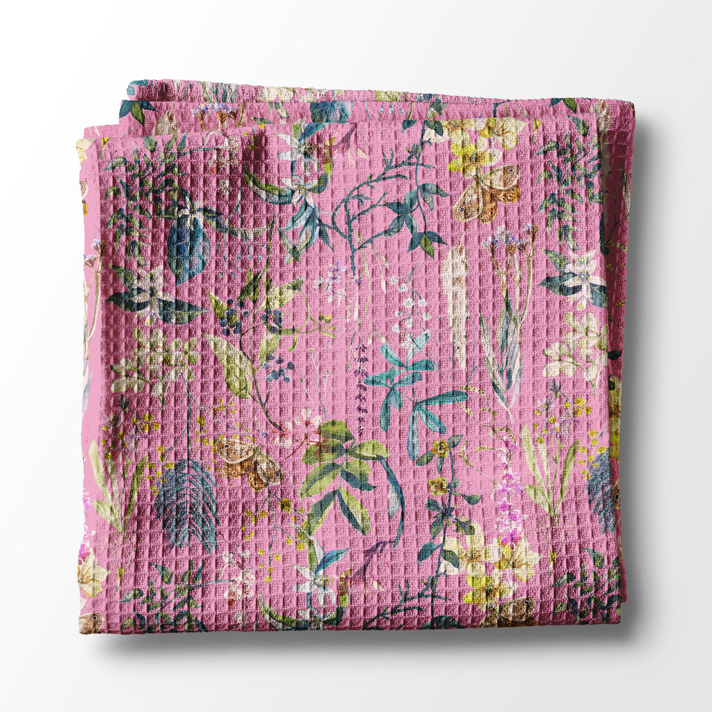 Folded pink floral kitchen towel on a white background
