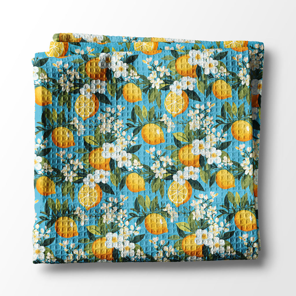 Floral and lemon-patterned kitchen towel on a white background