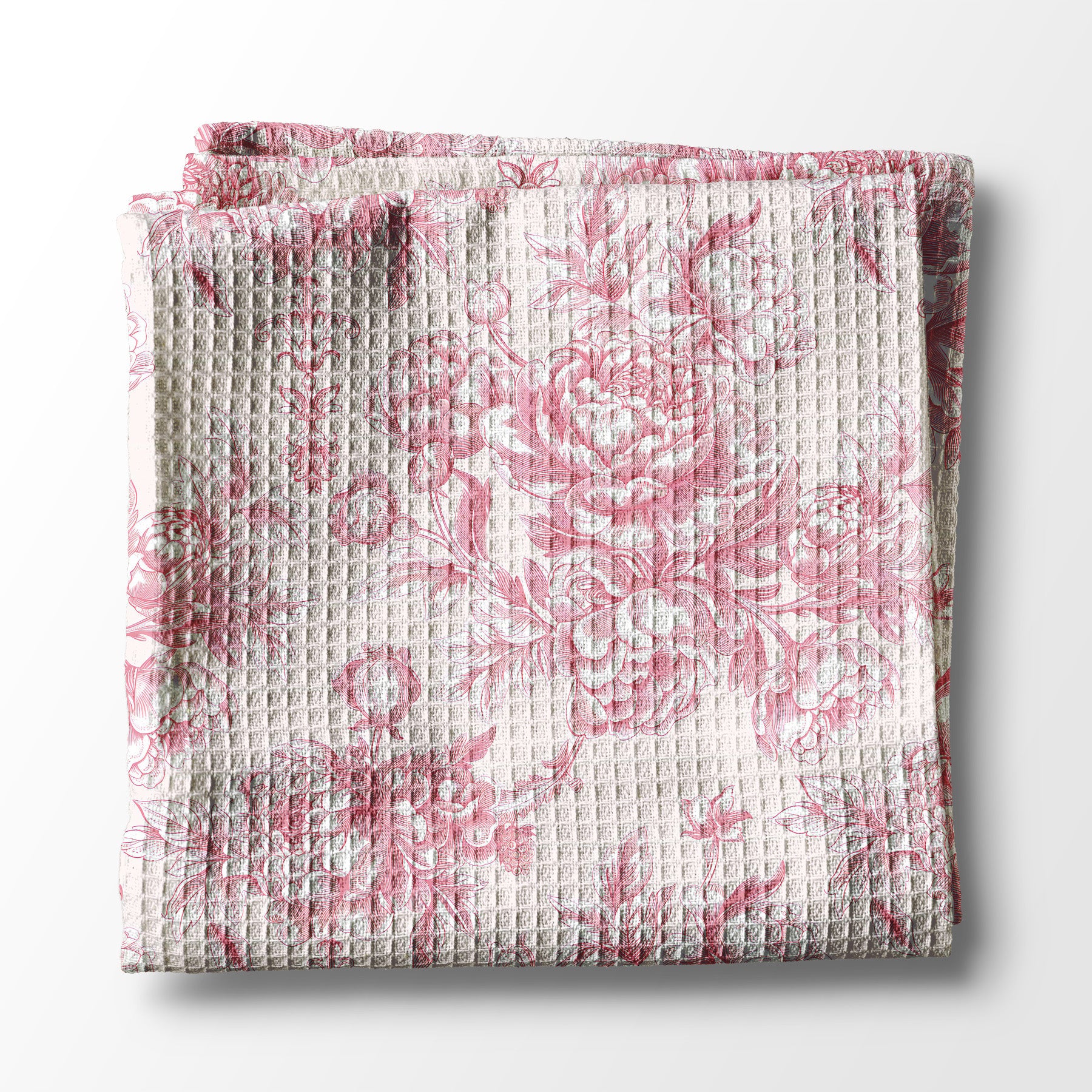Folded kitchen towel with pink floral pattern on a white background