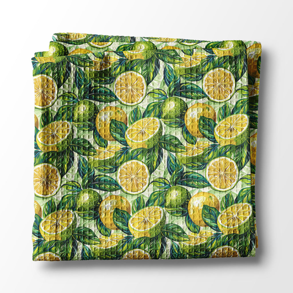 Folded kitchen towel with lemon and leaf pattern on a white background