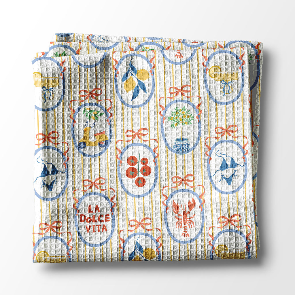 Decorative kitchen towel with colorful patterns and 'La Dolce Vita' text on a white background