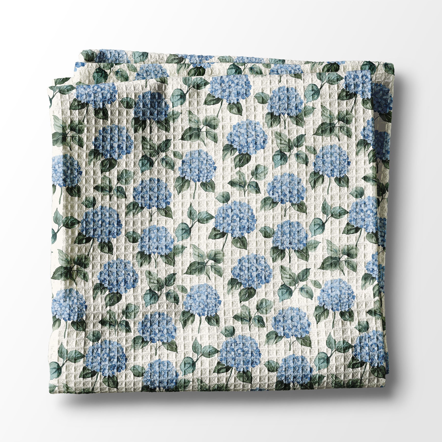 Floral patterned kitchen towel with blue flowers and green leaves on a white background