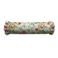 Floral patterned cylindrical pillow on a white background