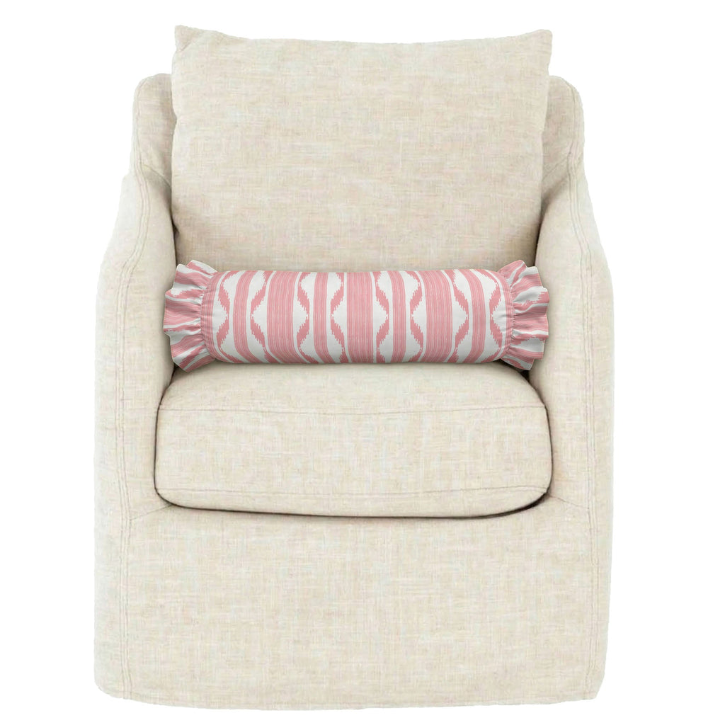 Beige armchair with a pink and white patterned cylindrical pillow on a white background