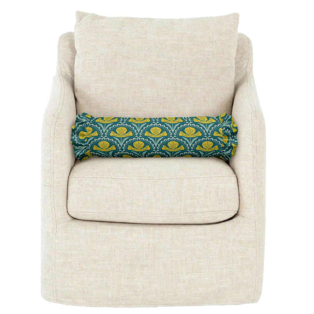 Beige armchair with a decorative pillow featuring blue and yellow patterns on a white background