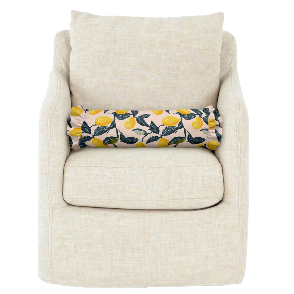 Beige armchair with a decorative pillow featuring lemon pattern on a white background