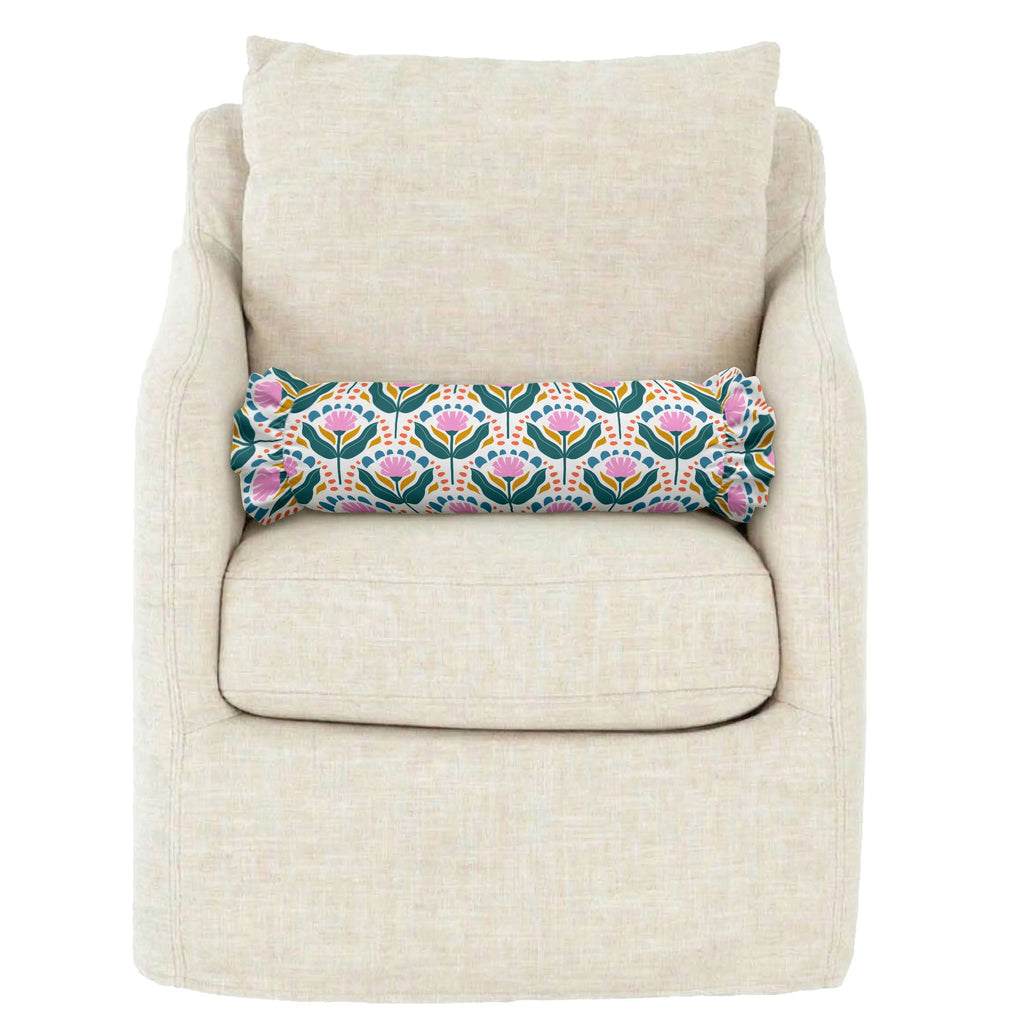 Decorative floral pillow on a beige armchair against a white background