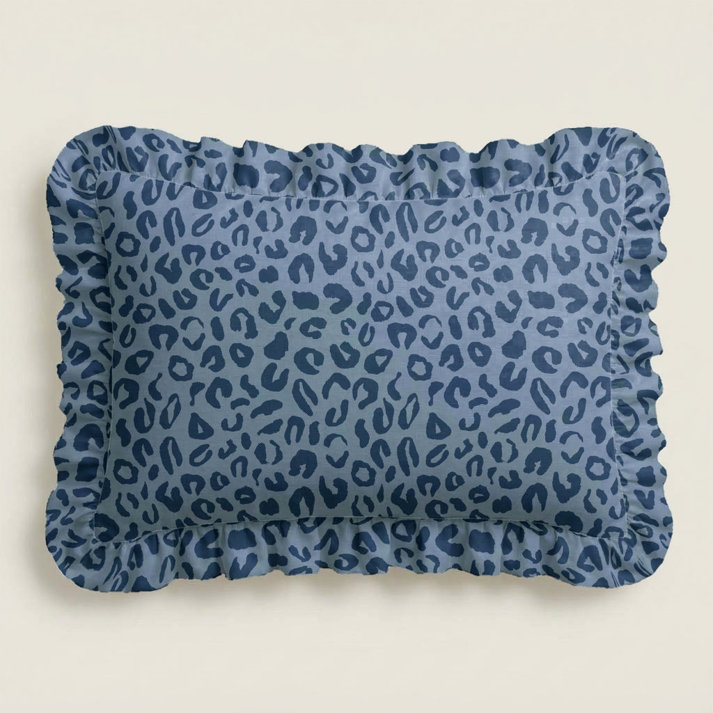 Blue leopard print pillow with ruffled edge on a beige background