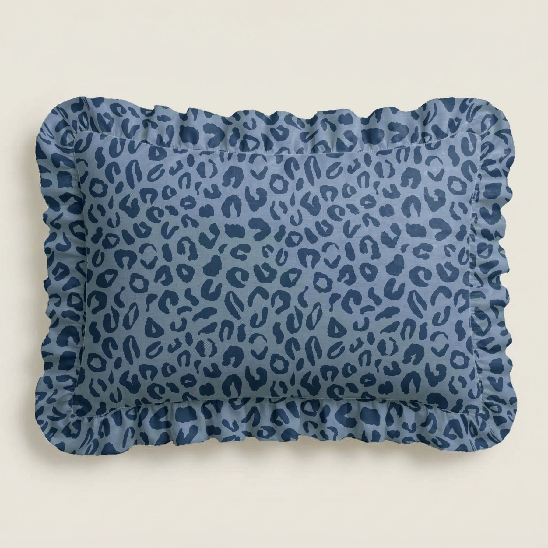 Blue leopard print pillow with ruffled edge on a beige background