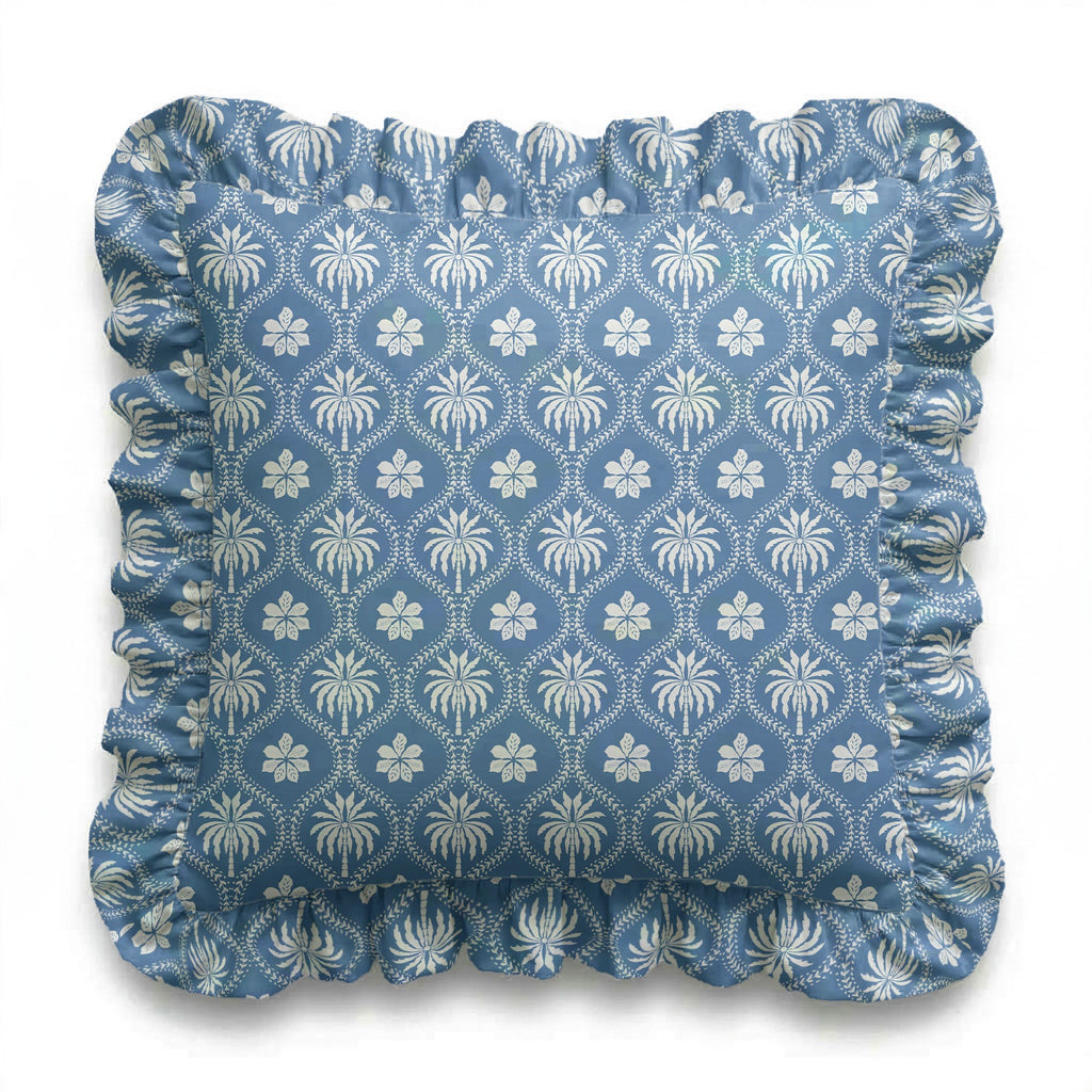 Blue cushion with white floral pattern on a white background