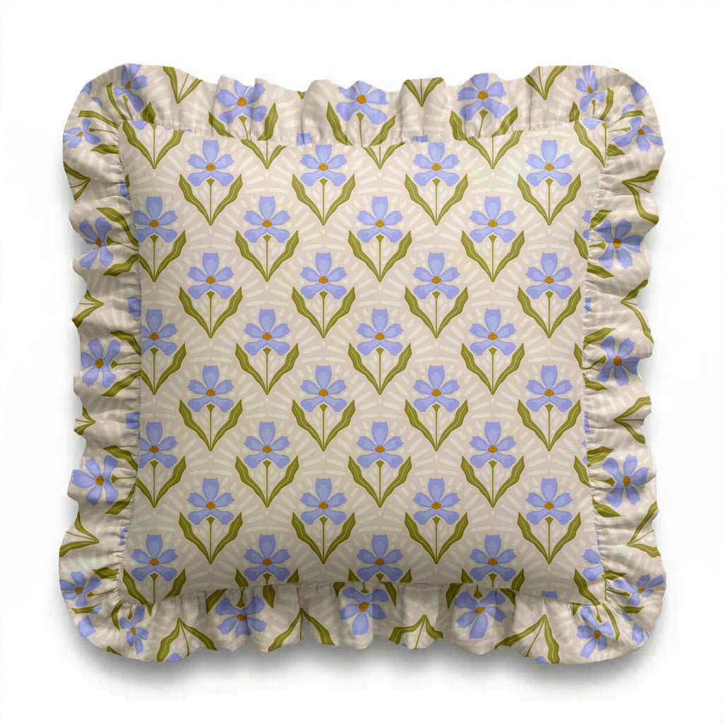 Floral patterned cushion with blue flowers and green leaves on a beige background