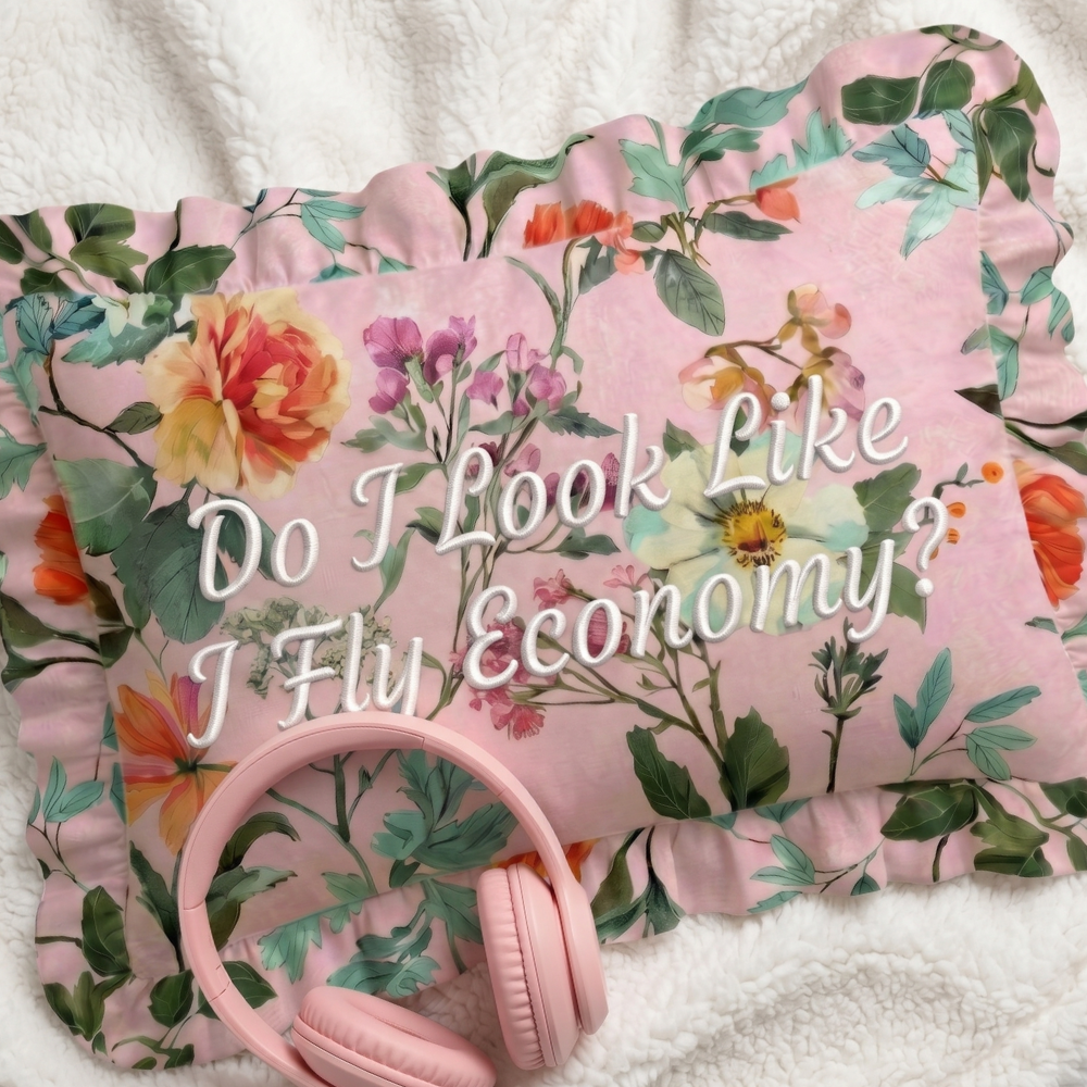 Floral pillow with text and pink headphones on a white background