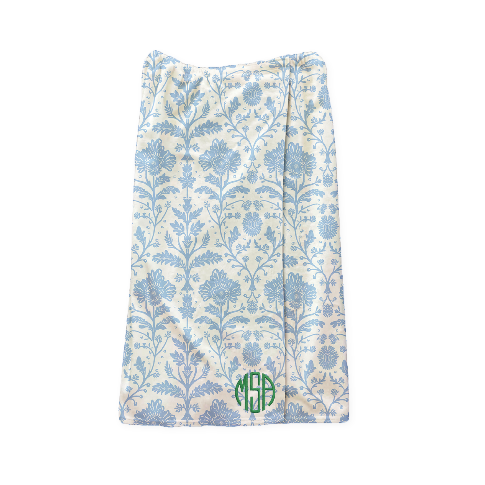 Delia Delft pattern on a wrap towel with green monogram embroidered on a white background