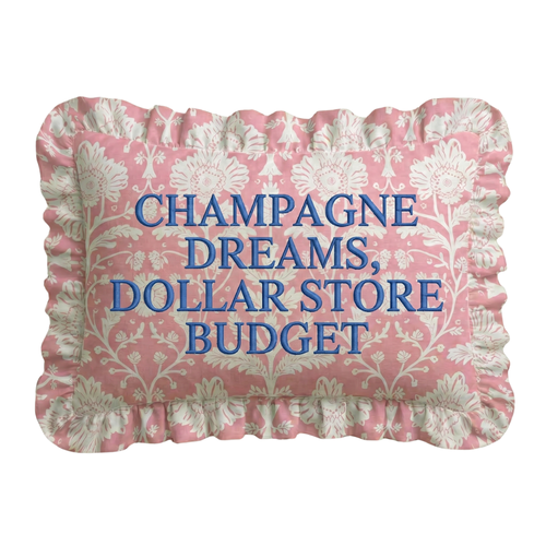 Decorative pillow with floral pattern and text 'Champagne Dreams, Dollar Store Budget' on a white background