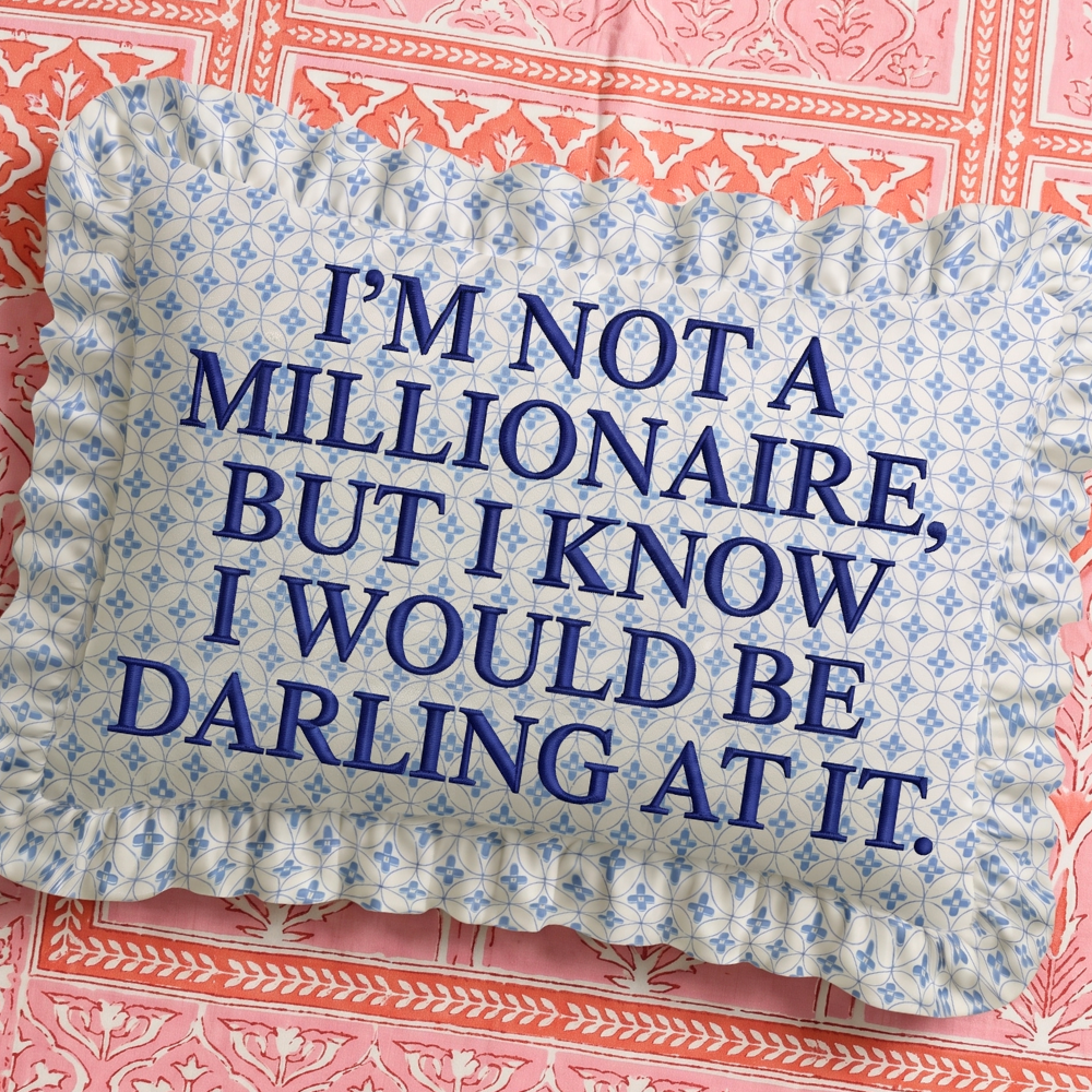 Decorative pillow with blue text on a floral patterned background